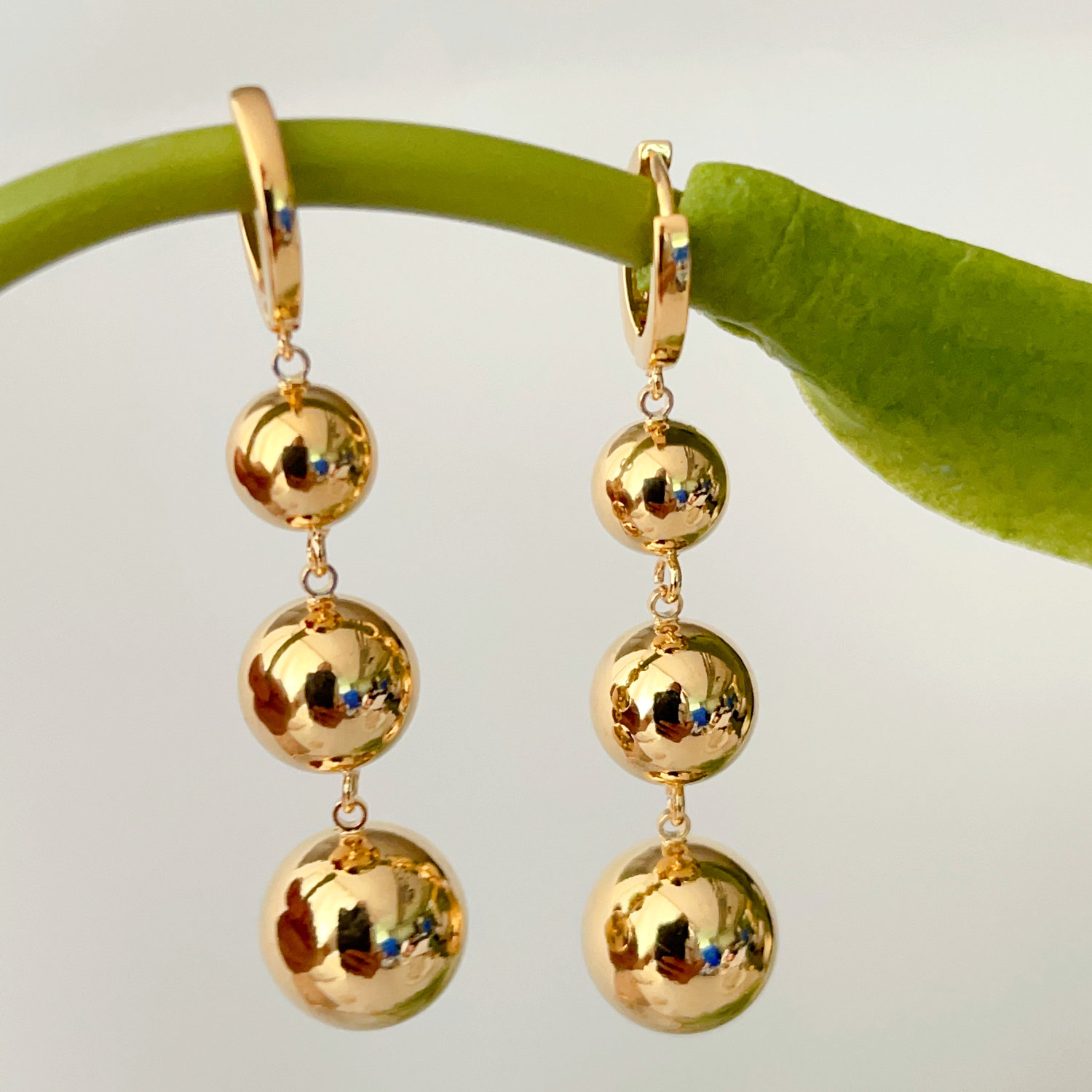 Three gold ball earrings
