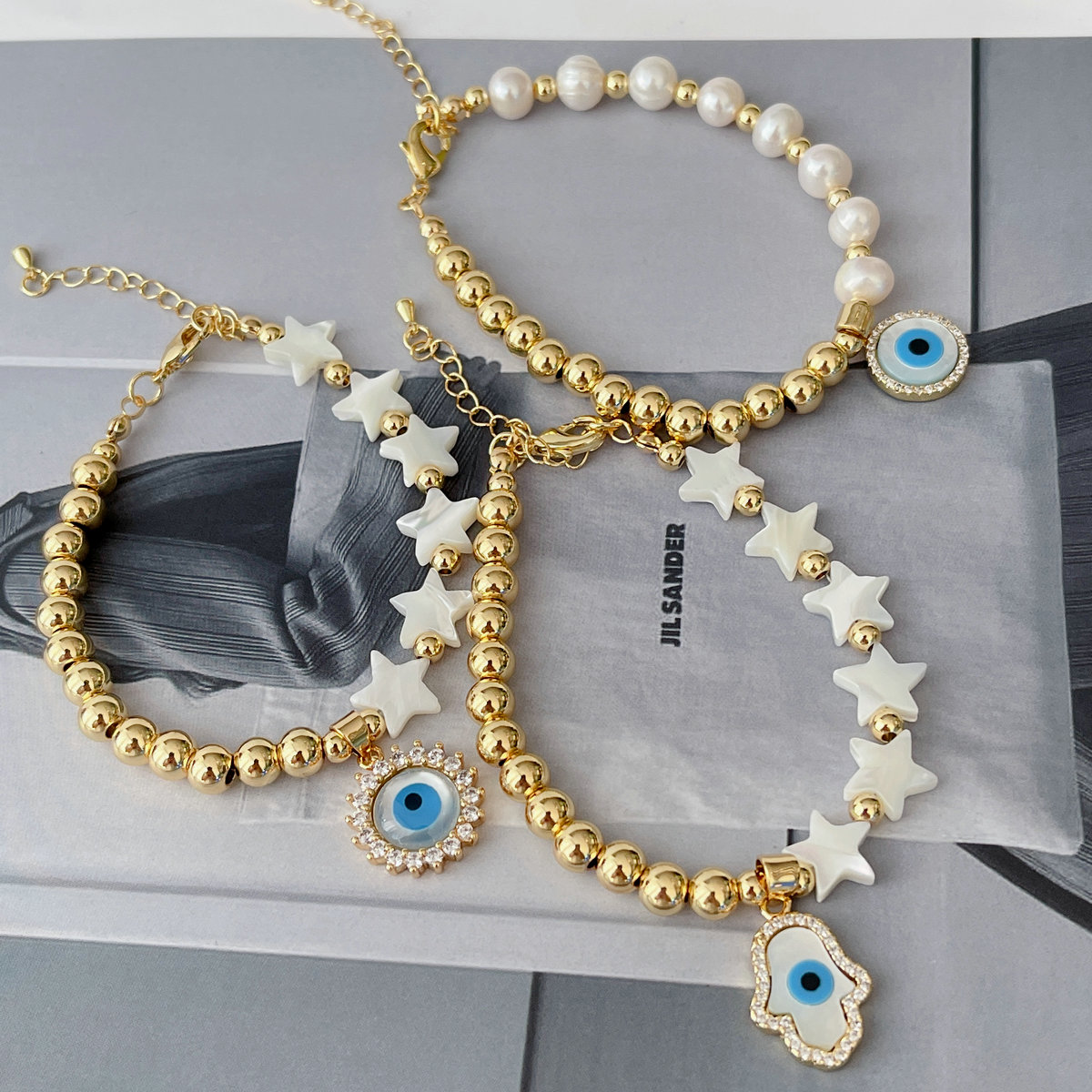 Half gold ball half pearl bracelet with mop evil charm