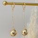 Long gold ball earrings