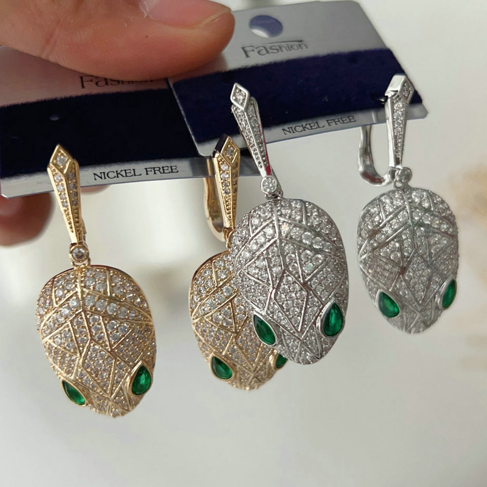 Pave green eye snake earrings