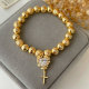 Gold ball bracelet with heart charm
