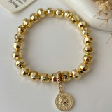 Gold ball bracelet with coin charm