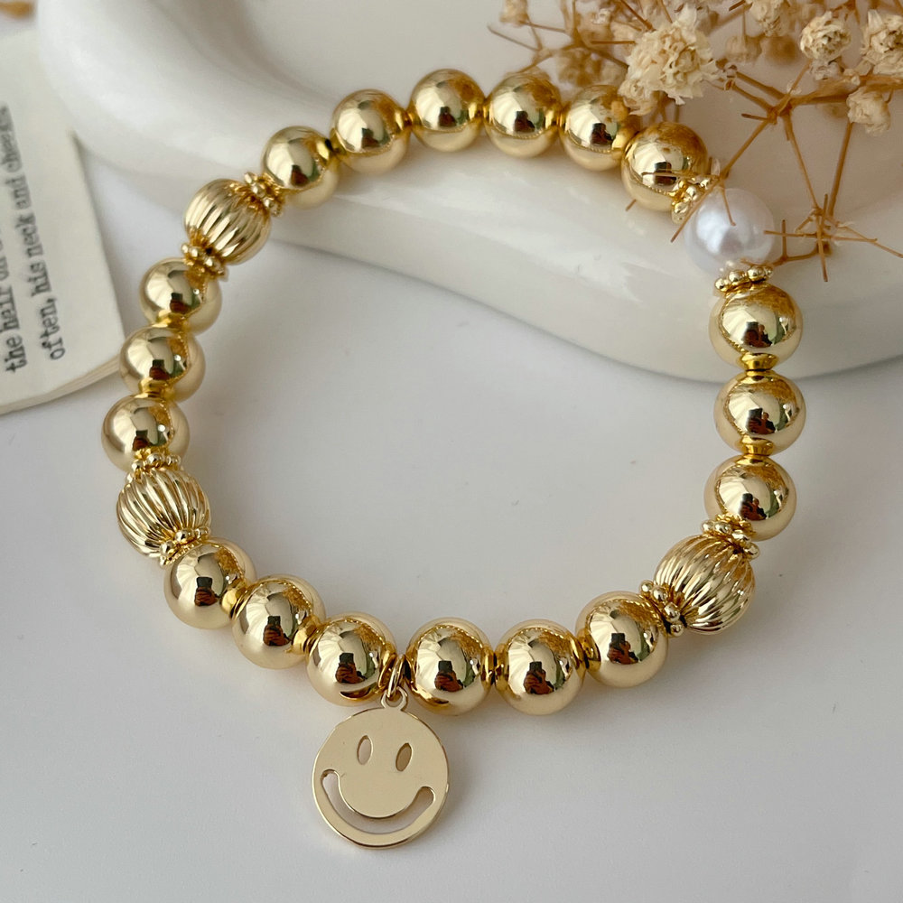 Gold ball bracelet with smile charm