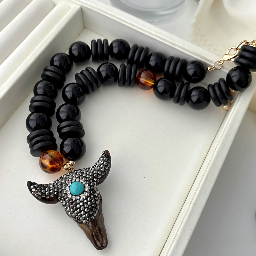 Black bead necklace with horn pendant