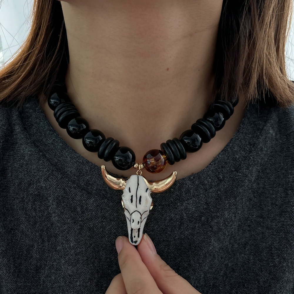 Black bead necklace with horn pendant