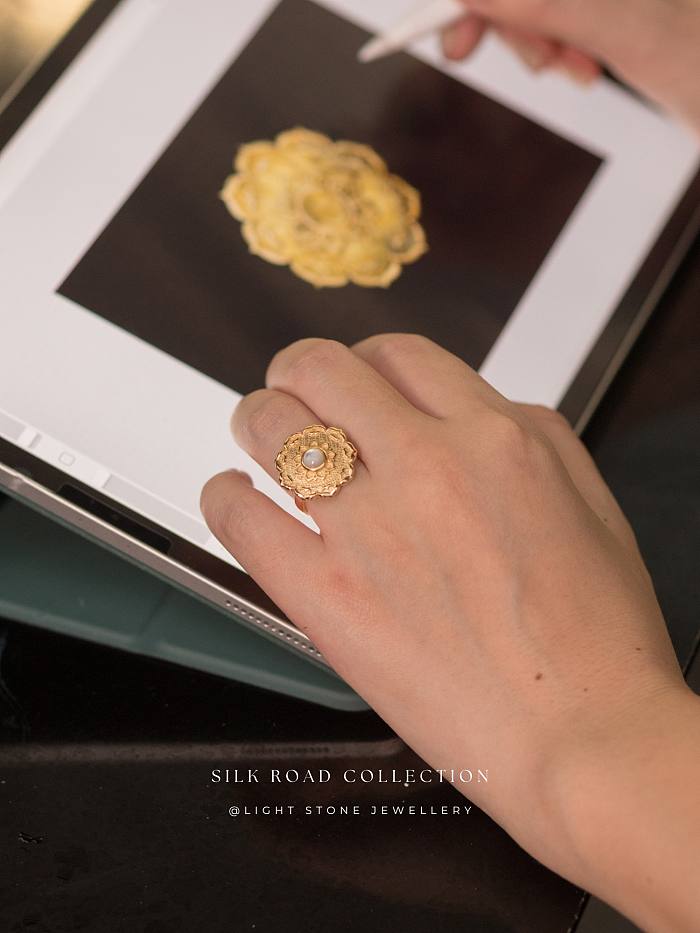 Handcrafted Lotus - Silk Road - Mother of Pearl - Luxury Sterling Silver Ring showcasing a delicate lotus design with a luminous pearl at the center, set against a textured, gold-plated sterling silver backdrop
