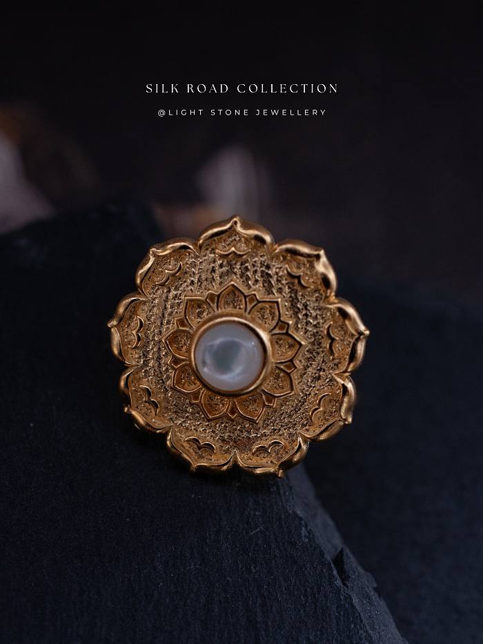 Handcrafted Lotus - Silk Road - Mother of Pearl - Luxury Sterling Silver Ring showcasing a delicate lotus design with a luminous pearl at the center, set against a textured, gold-plated sterling silver backdrop