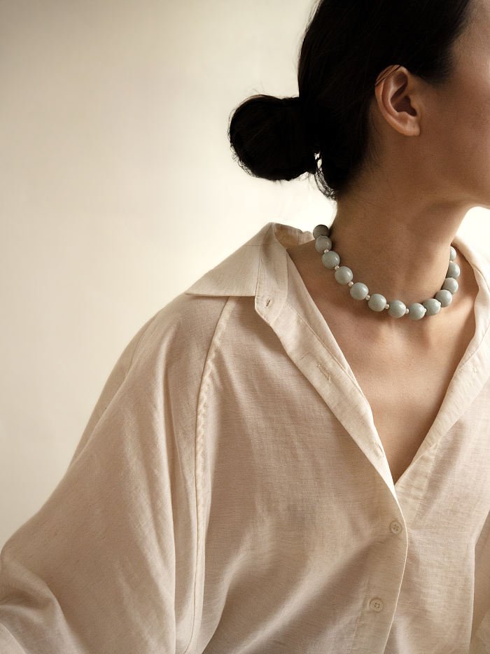 Side portrait of model in a neutral shirt with the choker resting just above the collarbone.