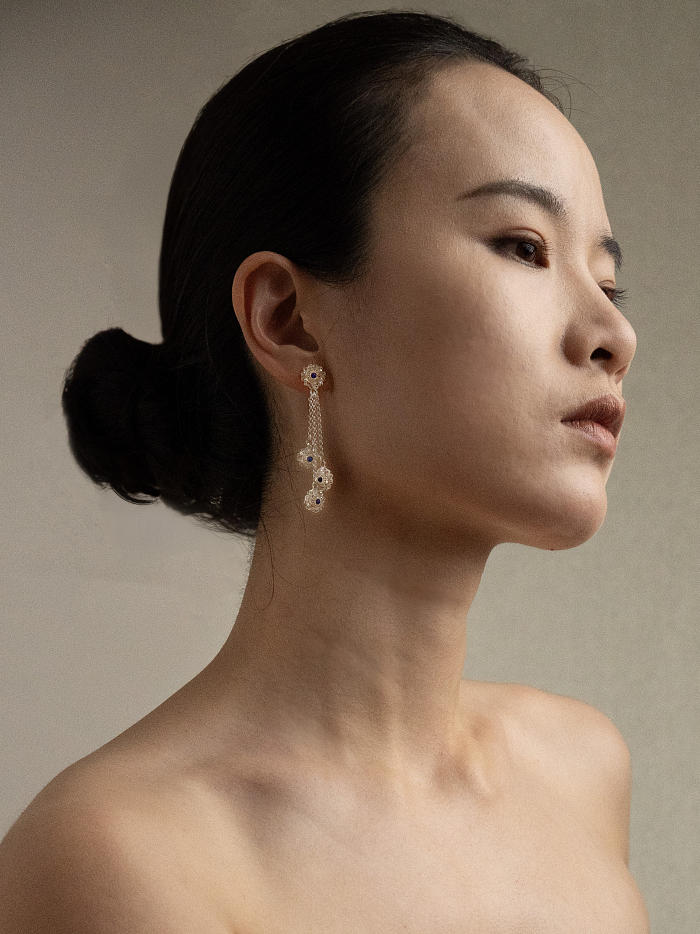 Model wearing Huasi Cascade Earrings in a sculptural profile pose under soft indoor lighting